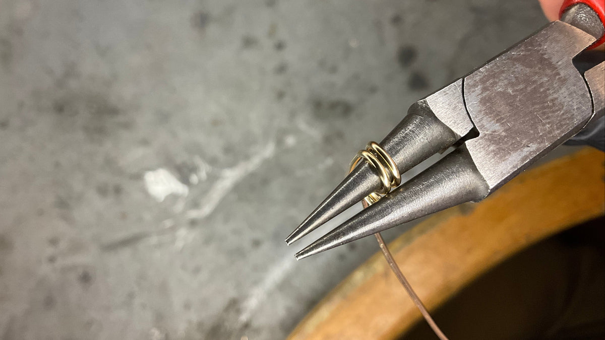 Filo d'oro avvolto sulla punta delle pinze, al banco del laboratorio