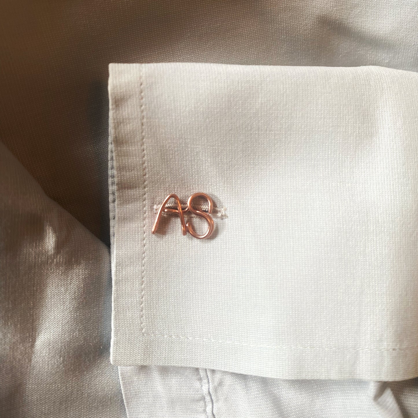 gemelli personalizzati con iniziali realizzati in oro giallo e indossati su una camicia bianca